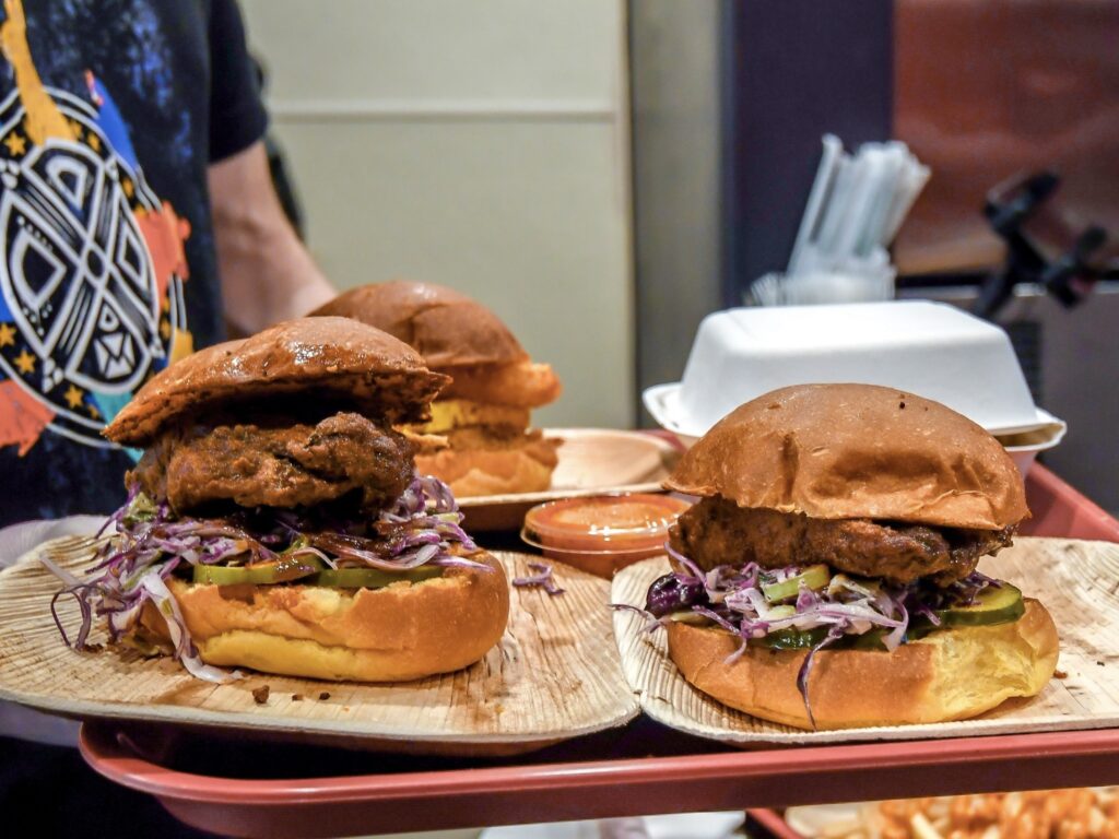 Algorithm Vegan Grill's Nashville Hot sandwich uses brined Blackbird Seitan, dredged in seasoned flour and lightly fried, with homemade bread and butter pickles in a sweet potato bun.