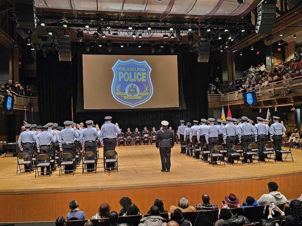 Philly-police-swearing-in New Philly Police officers take the oath of office as they stand on a stage.