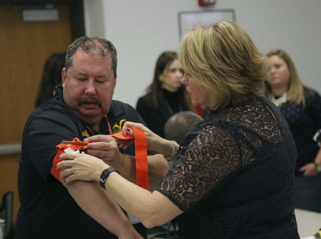 Stop The Bleeding One person applying a tourniquet to another's arm