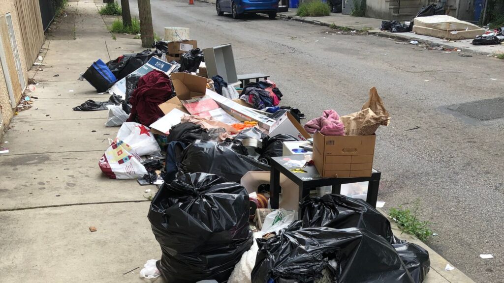 Littering is more than a stain to the eye A sidewalk filled with ripped trash bags and litter
