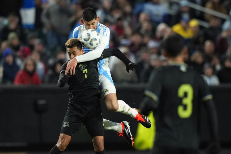 El Salvador's Darwin Ceren, left, and Argentina's Cristian Romero battle for the ball during the first half of a friendly soccer match