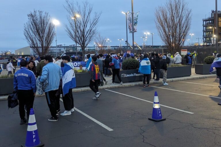 Fans of El Salvador's soccer team gather in a parking lot outside of the stadium
