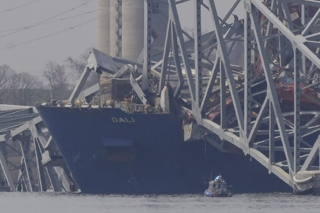 A container rests against wreckage of the Francis Scott Key Bridge