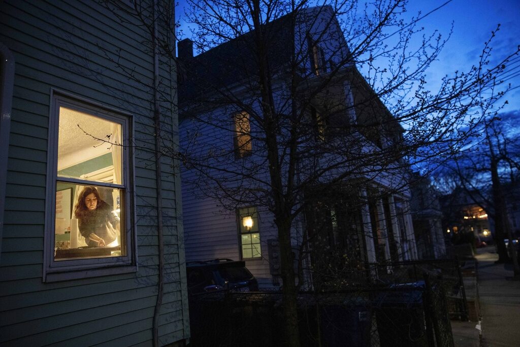 McKenna Shuster McKenna Shuster is visible through a window working in her house at twilight.