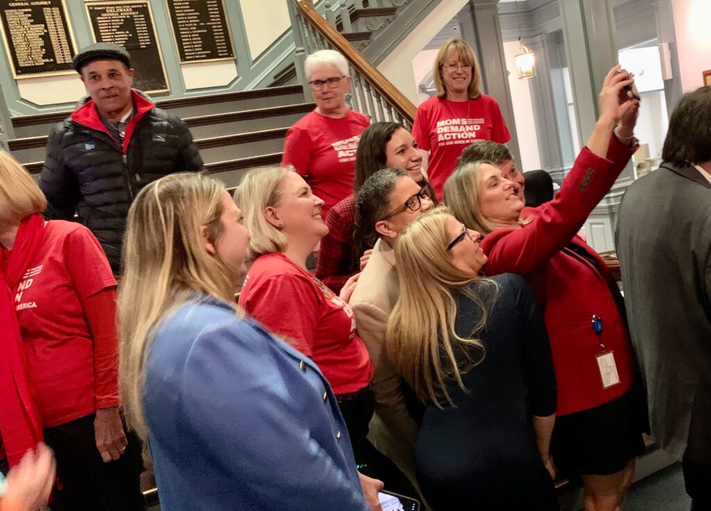 delaware-gun-bill-s-mueller-2024-03-08-1 Moms Demand Action group in red shirts take a selfie with lawmakers