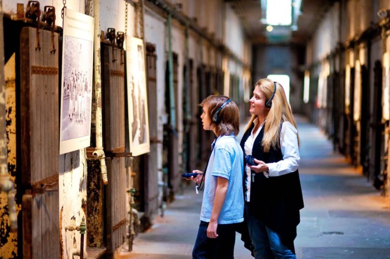 Visitors look at an exhibit on the wall at the Eastern State Penitentiary Historic Site.