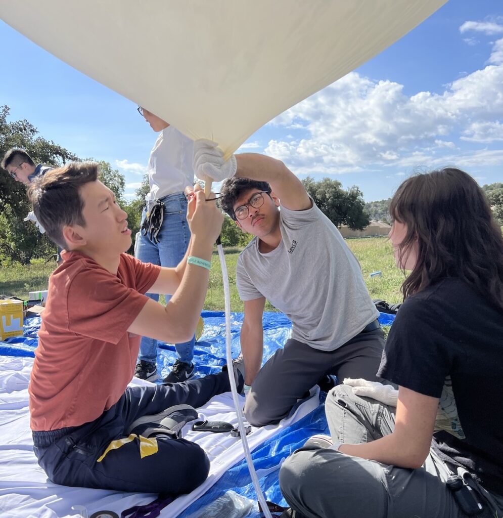 Researchers prepare a balloon device for an experiment during a solar eclipse