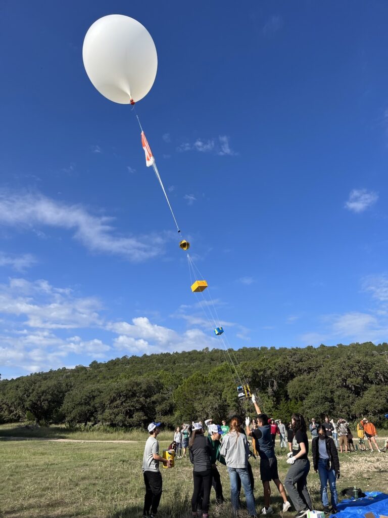 Researchers prepare a balloon device for an experiment during a solar eclipse
