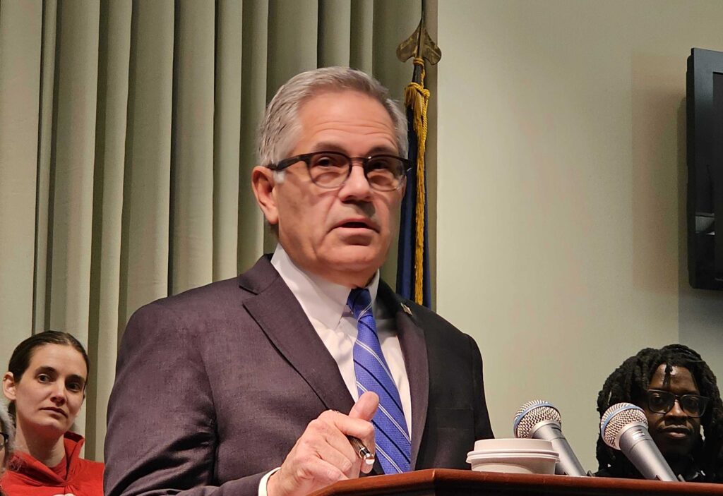 insulin-da-t-macdonald-2024-03-25-1 Larry Krasner speaking at a podium.