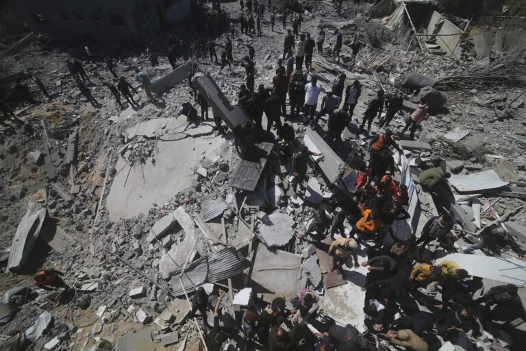 Palestinians look at a residential building destroyed in an Israeli strike in Rafah, Gaza Strip, Tuesday, March 20, 2024.