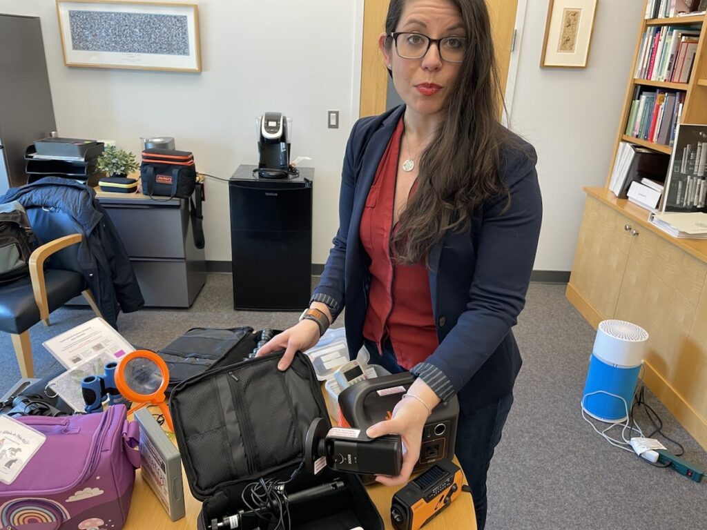 Becky Bowers poses with several gadgets and other high-tech things