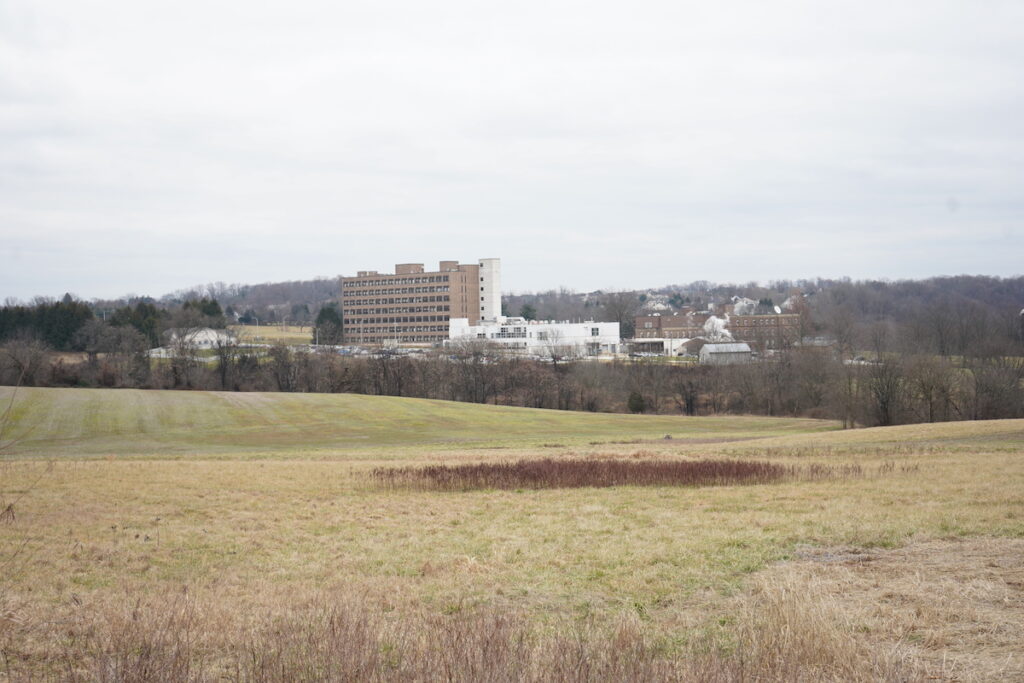 An open field with buildings in the distance.