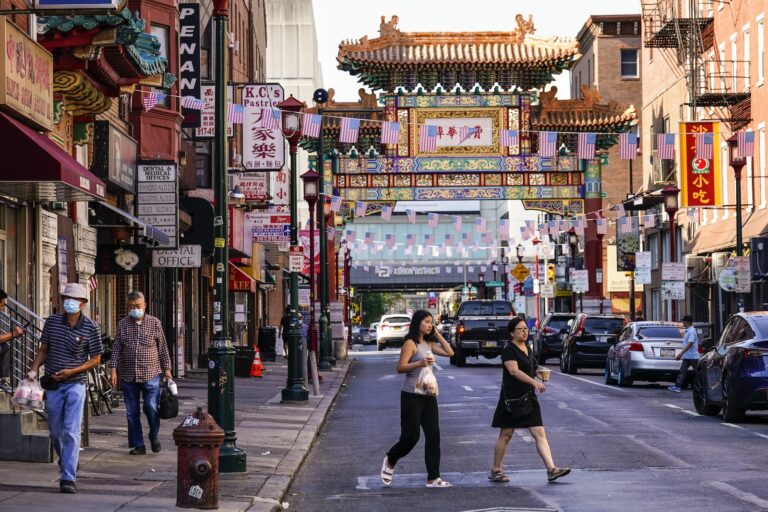 Pedestrians cross 10th Street in the Chinatown neighborhood of Philadelphia, July 22, 2022.