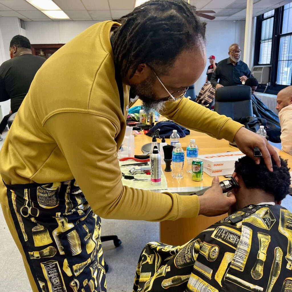 Mount Airy barber Jahmeil Ragin cuts a student’s hair at a free barber event at Simon Gratz High School.