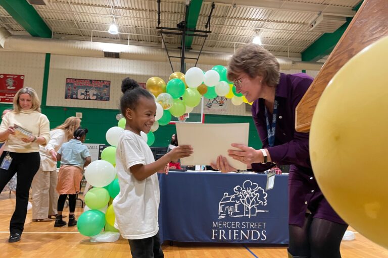 Karen Driscoll hands a certificate to a child