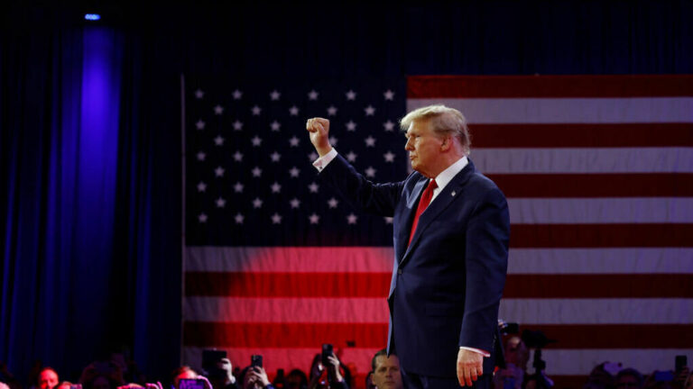 Donald Trump raises his fist onstage
