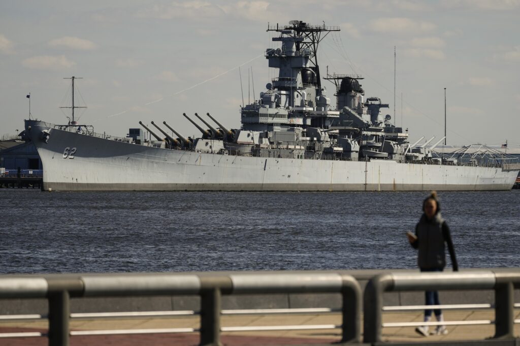 World War II Battleship-USS New Jersey A person walks in Philadelphia across the Delaware River from the USS New Jersey in Camden, N.J., Tuesday, March 19, 2024.