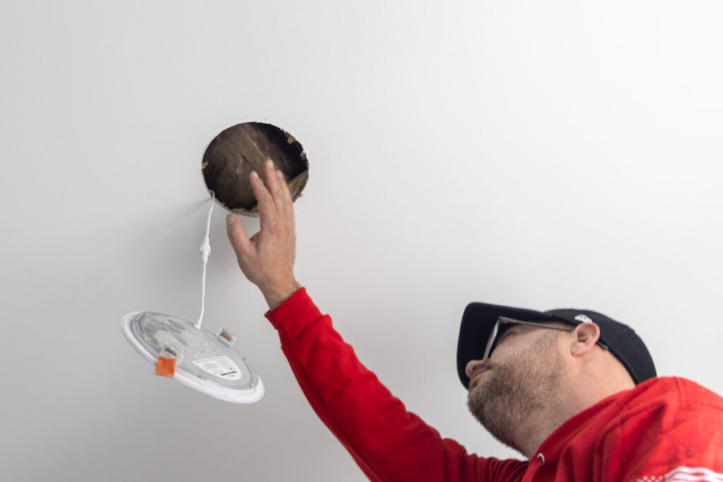 Ori Rosenkratz checks for air leakages behind light fixtures in a home