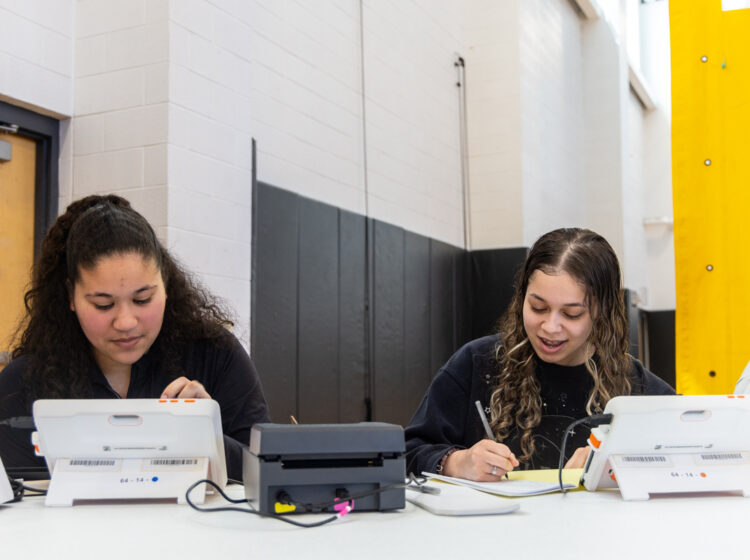 Poll workers Maria Moreira, Lincoln High School class of ’23 (left) and senior Victorya Santos at work in the school’s gymnasium