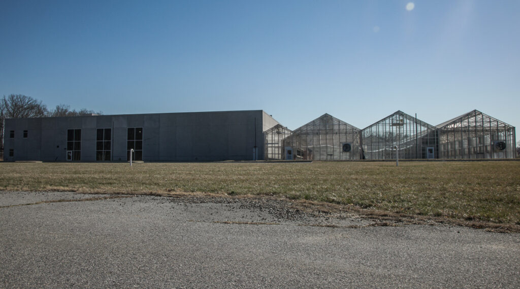 A building and greenhouses on the same campus as Versogen’s labs where the company plans to test the creation of green hydrogen using solar panels.
