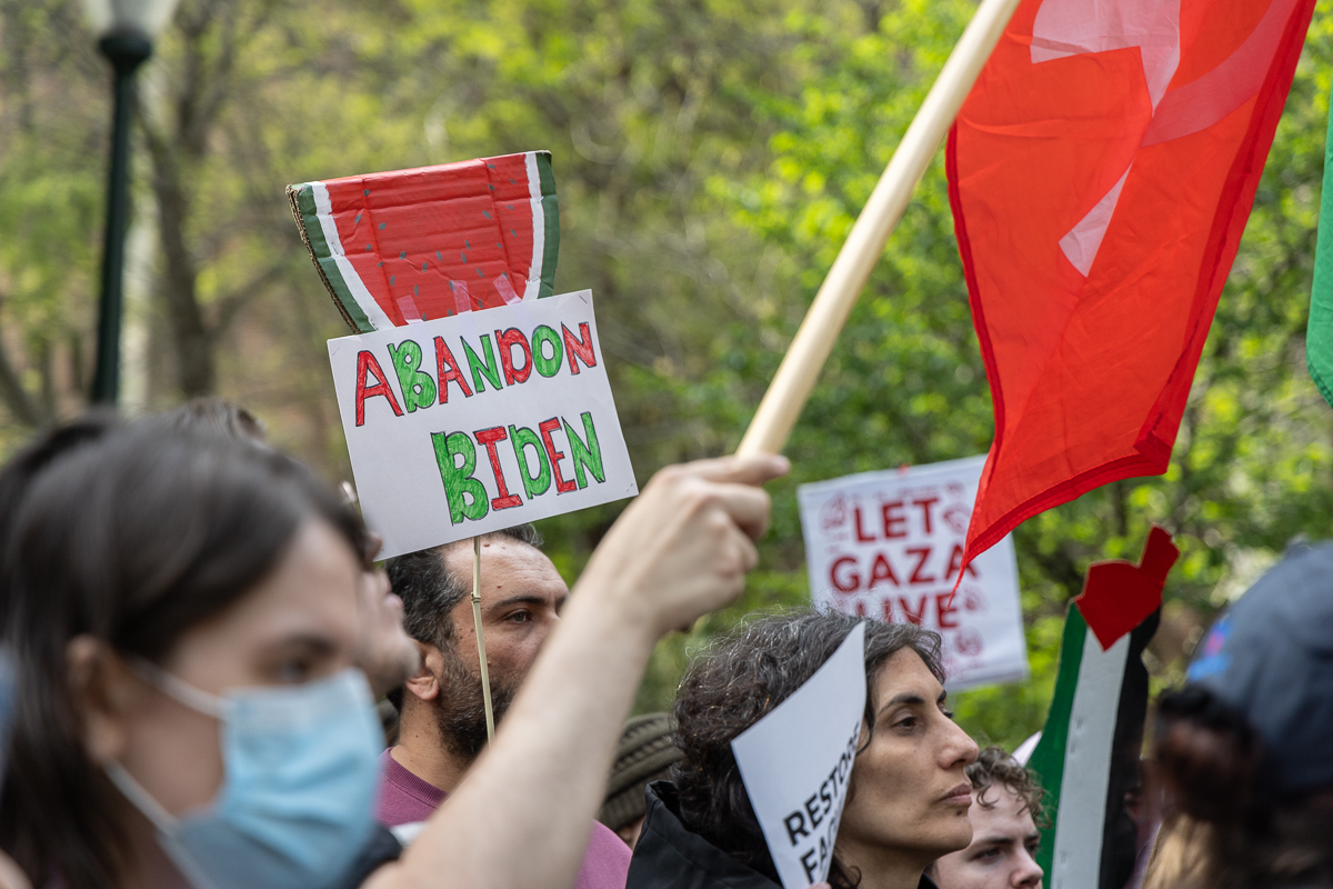 A protest sign featuring a watermelon says 'Abandon Biden'