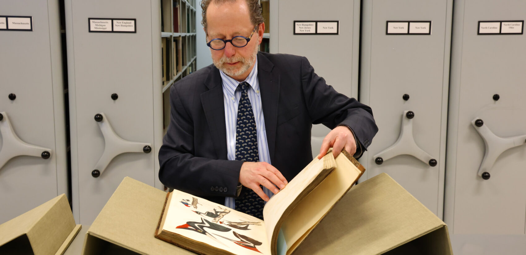 David Brigham looks through a volume of Alexander Wilson's book American Ornithology