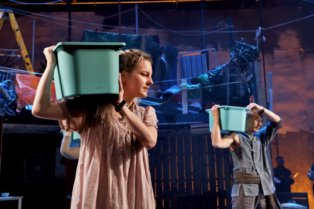 2024 03 28-e lee-philadelphia wilma theater-good person of setzuan bins Recycled plastic bins become props and percussion instruments for the cast of ''The Good Person of Setzuan'' at Wilma Theater. (Emma Lee/WHYY)