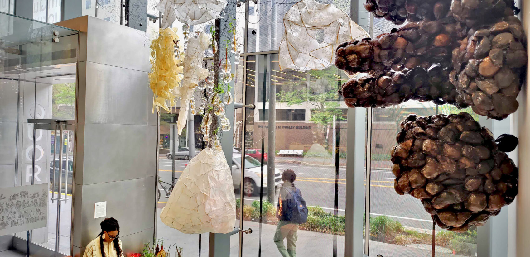 Artist Jasmine Murrell sits underneath her installation