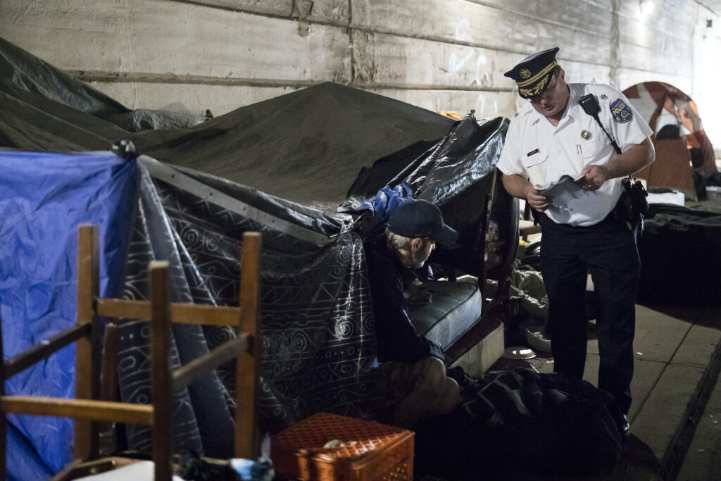 Police officer evicting a homeless person