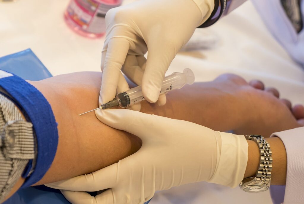Dr. drawing blood from a patient