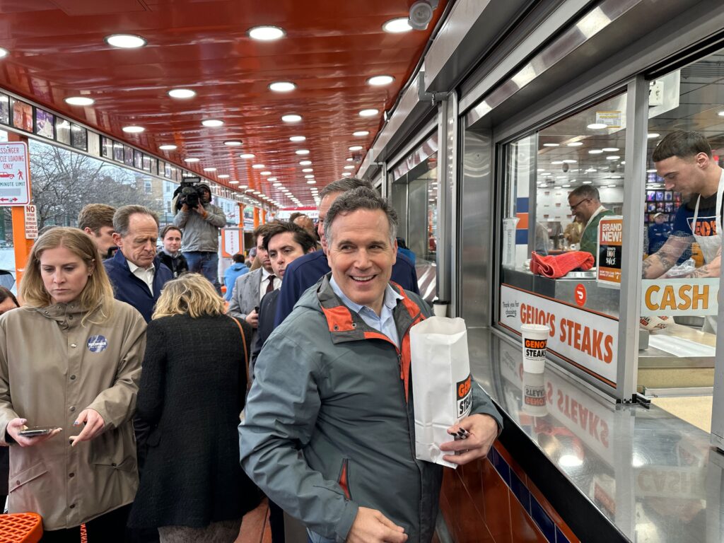 david-mccormick-genos-1 David McCormick orders several Philly cheesesteaks from the window at Geno’s Steaks in South Philly. (Carmen Russell-Sluchansky/WHYY)