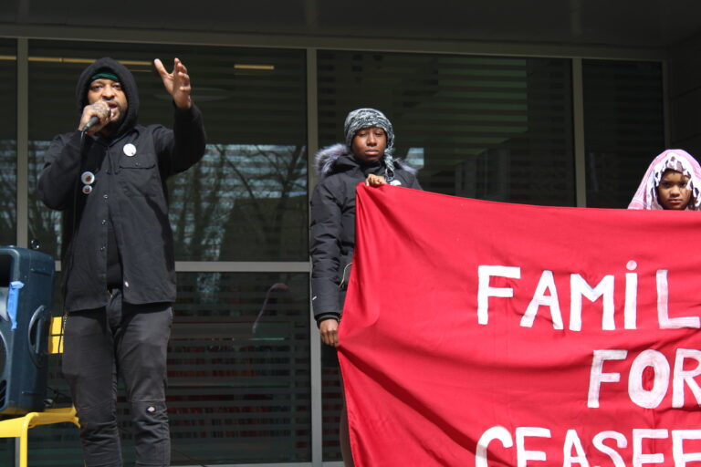 Lindo Jones speaking into a mic at the rally