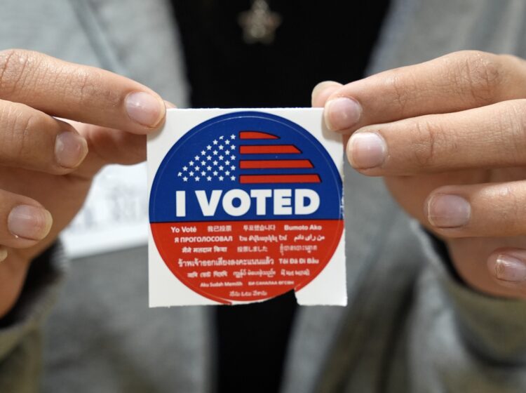 An election volunteer offers voters an 