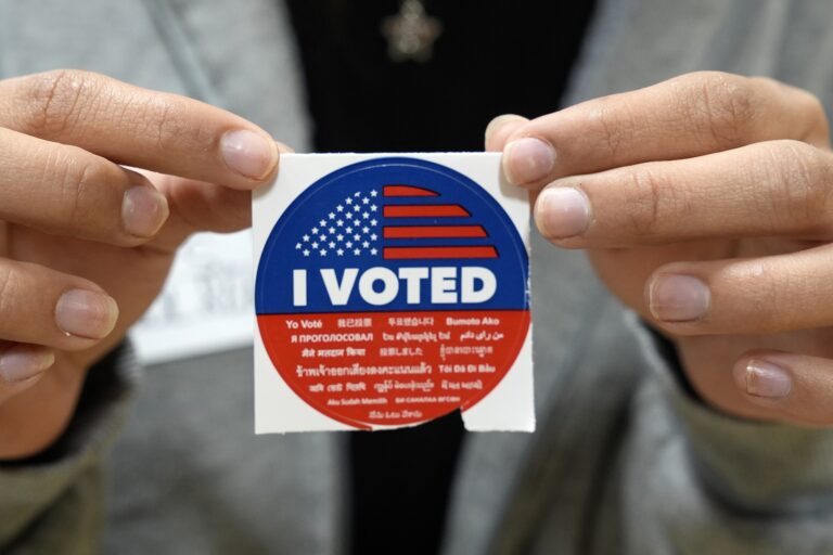 An election volunteer offers voters an 