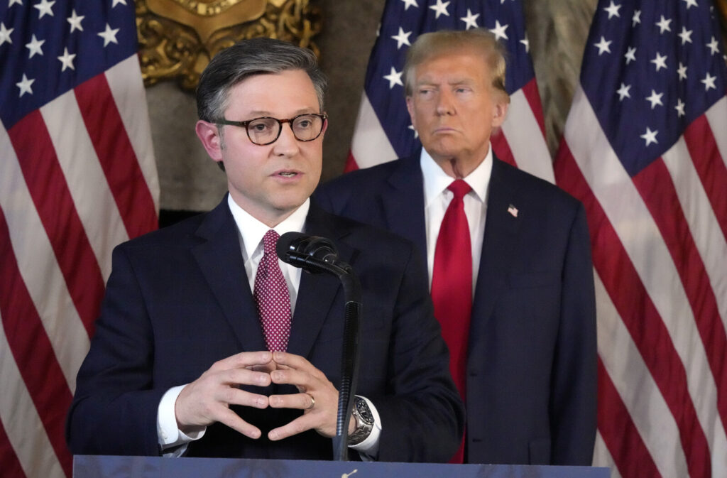 MIke Johnson speaking with Donald Trump standing behind him