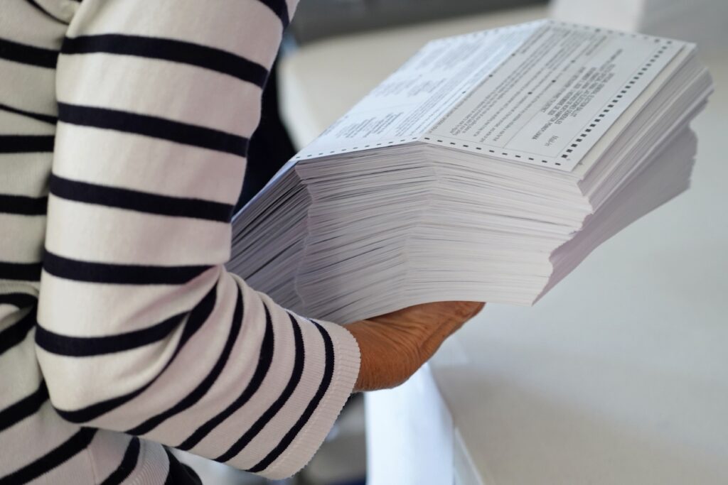 mail-ballots-northampton-county-spotlight-pa-2024-04-03 A woman is holding a stack of mail ballots