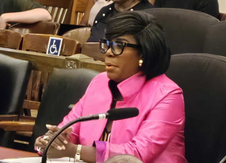Cherelle Parker speaking into a microphone at a table