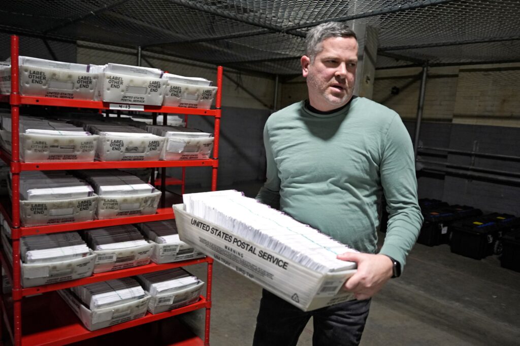 pittsburgh-mail-in-ballots Allegheny County Election Division Deputy Manager Chet Harhut carries a container of mail-in ballots in Pittsburgh
