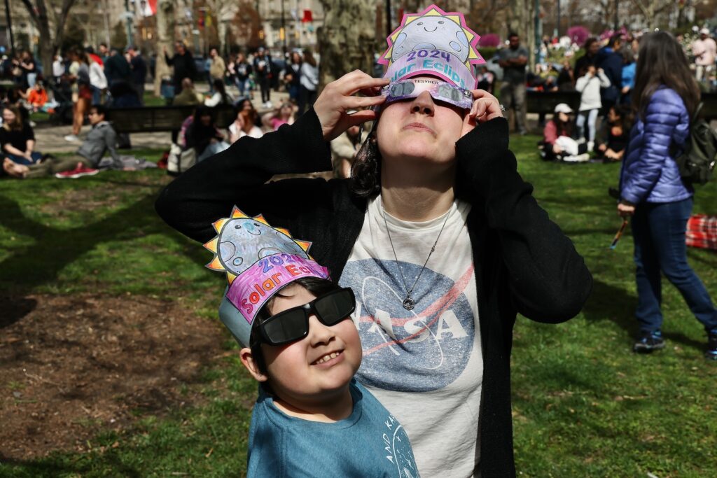 solar-eclipse-philadelphia-franklin-institute-EL-040824 Kasey Moore and 8-year-old daughter, Sadie, from Northeast Philadelphia wear homemade hats as they watch the eclipse outside the Franklin Institute in Center City