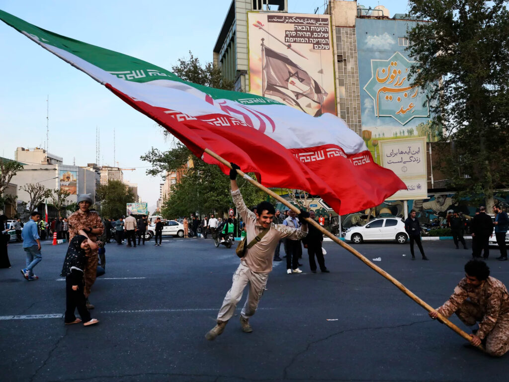 tehran-anti-Israeli-gathering Demonstrators wave a huge Iranian flag in Tehran