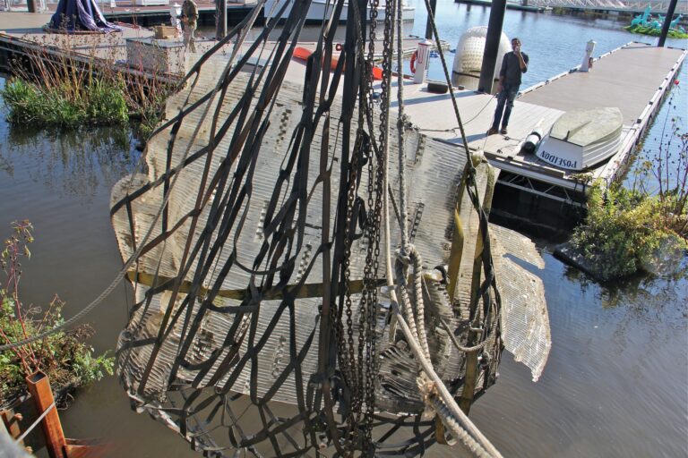 a piece of sculptor Miguel Horn's work being lifted out of the water with a net