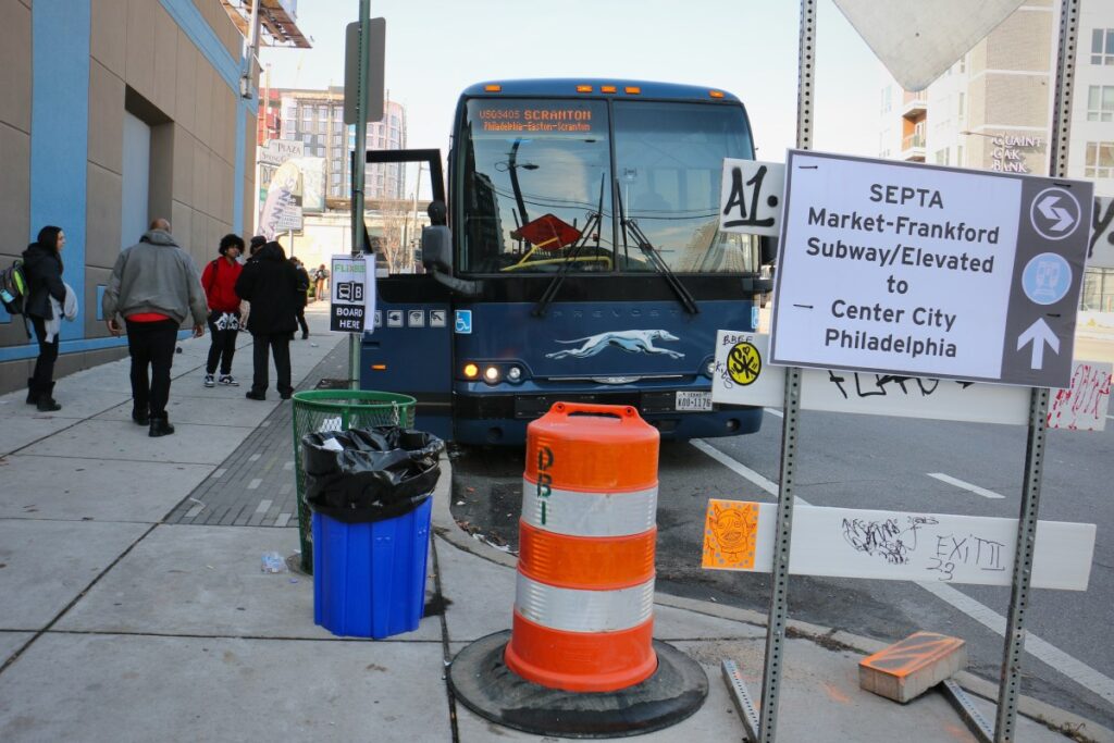 2023-12-08-e-lee-philadelphia-spring-garden-street-waiting-for-the-bus-subway-sign People boarding a bus