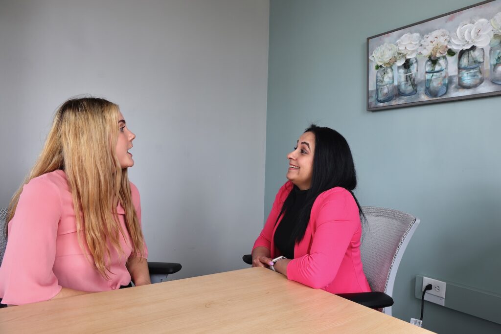 Hannah Spittle (left), a bilingual learning an development specialist with Mental Health Partnership chats with Odalis Delgado, who went through the partnership's two-week intensive training a certified peer support specialist.