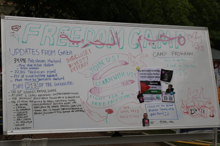 A marker board at the encampment provides updated stats for the ongoing Israel-Hamas War, specifically the impact on Palestinians in Gaza. (Cory Sharber/WHYY)