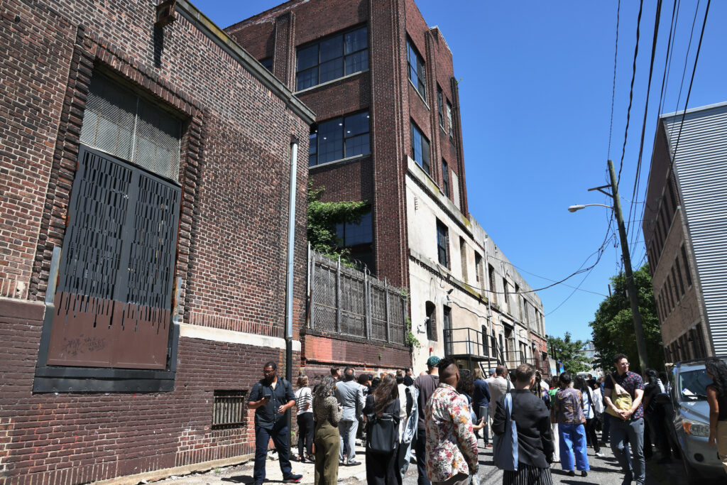 2024 05 30-e lee-philadelphia kensington-forman arts initiative campus block People walk the sidewalk off North American Street
