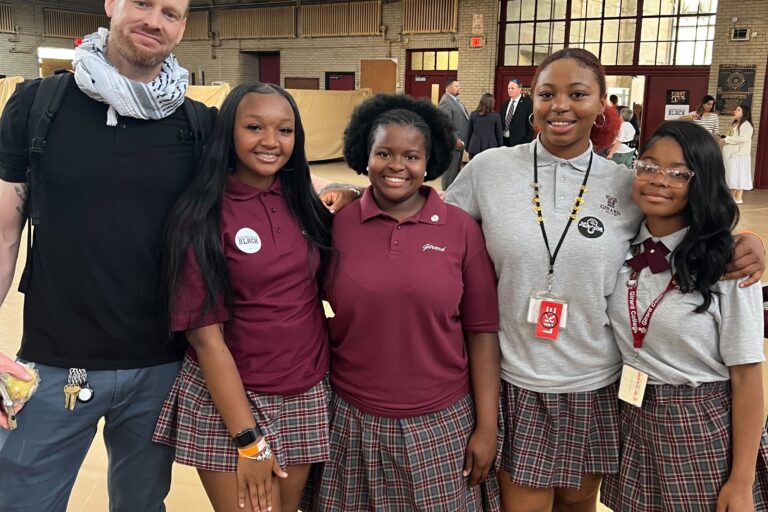 A teacher posing with several students.