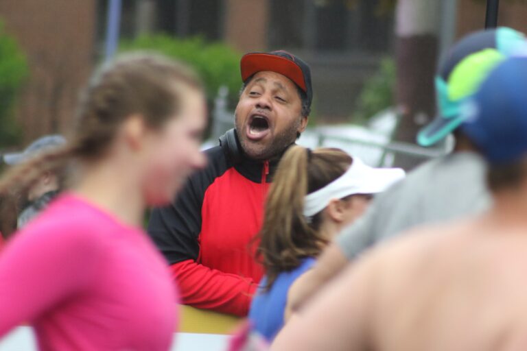 a supporter cheers the runners on