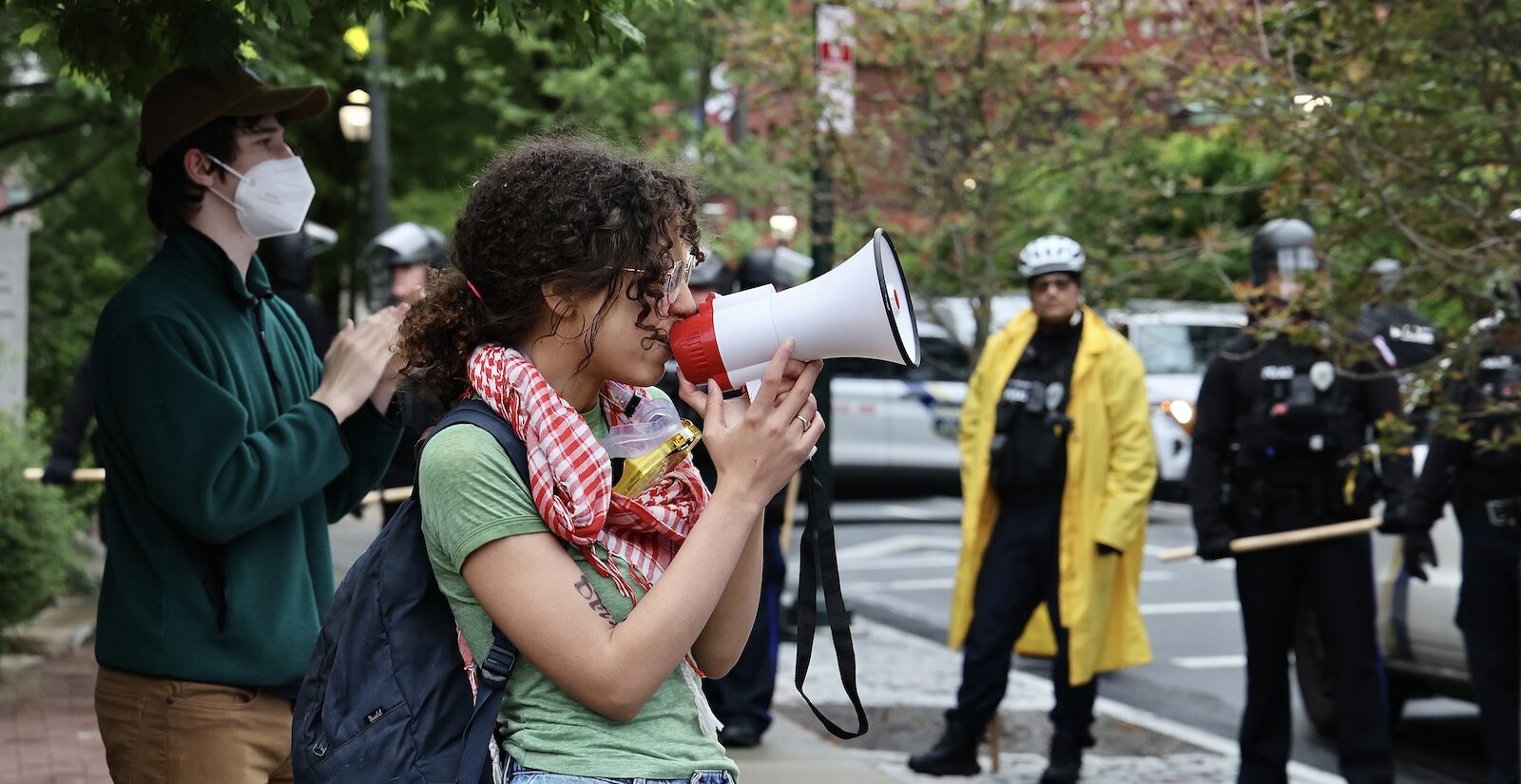 Penn alumna Zoe Sturges leads a protest chant as police clear the encampment on the College Green.