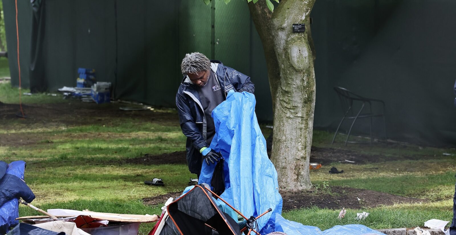 A worker clears away a tent on Penn’s college green.
