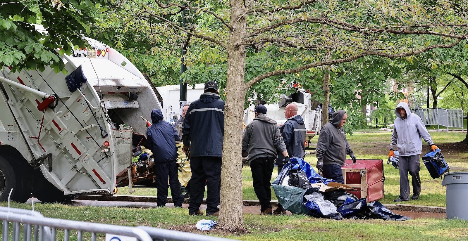 Workers load protesters tents and possessions into a garbage truck after clearing the the protest encampment on Penn’s college green.